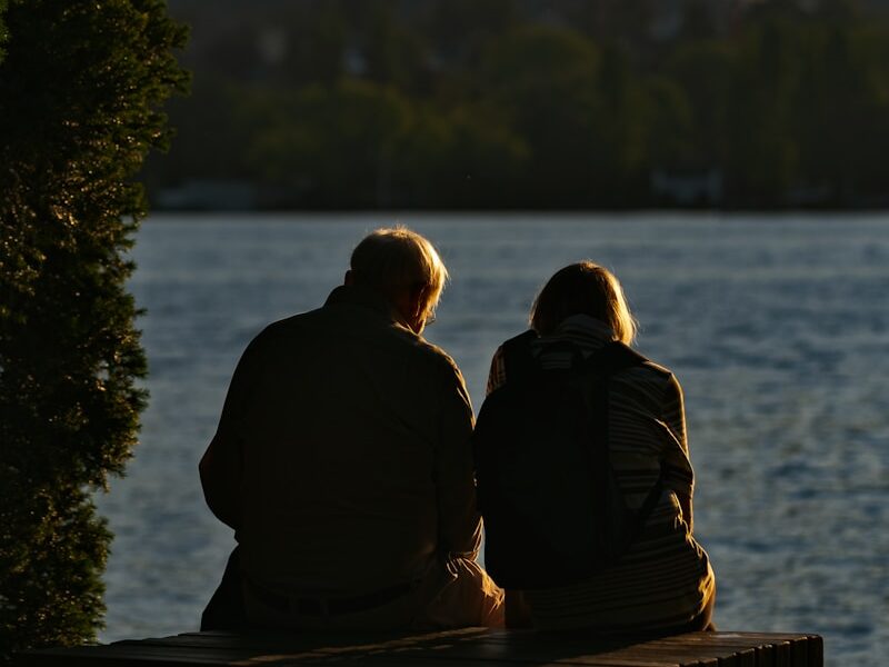 man and woman standing near body of water during daytime