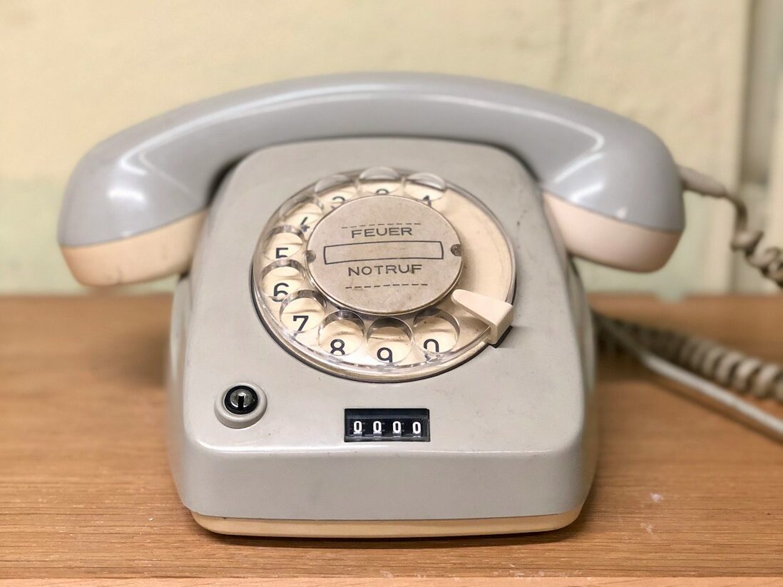 gray rotary telephone on brown table