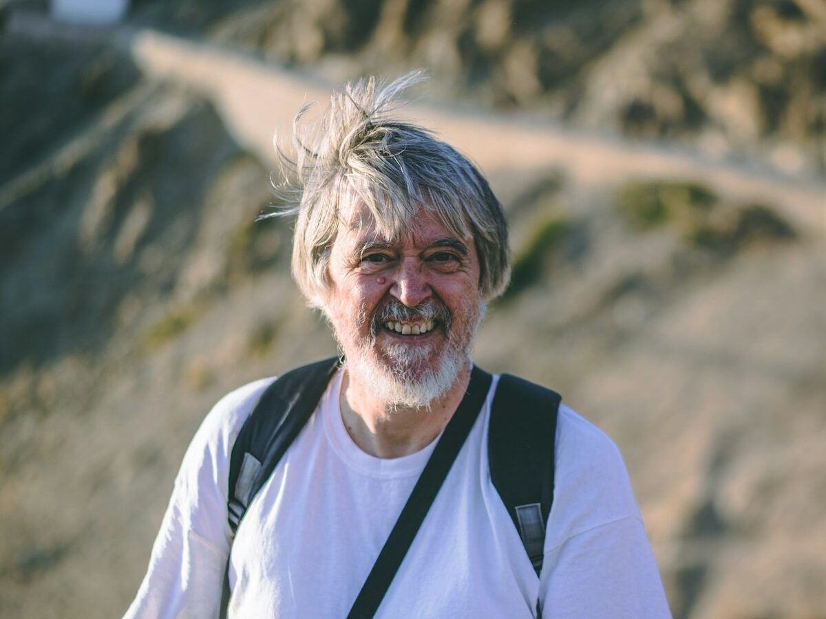 man wearing white crew-neck t-shirt with backpack
