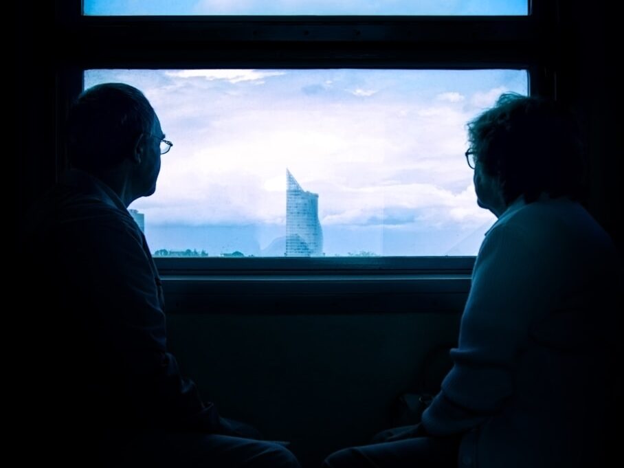 man and woman standing beside window