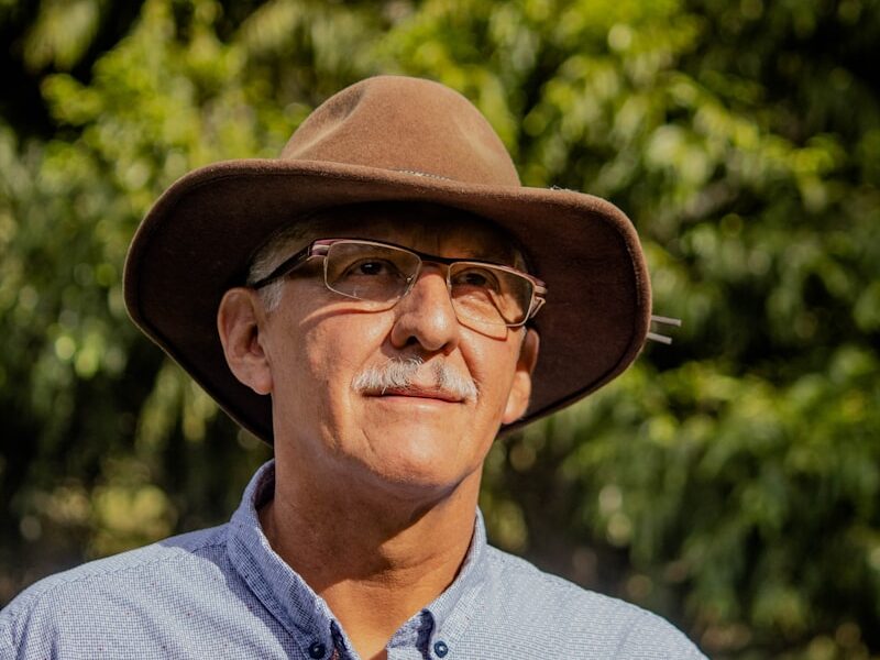 man in gray button up shirt wearing brown fedora hat