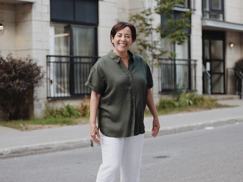 man in gray polo shirt and white pants standing on gray asphalt road during daytime