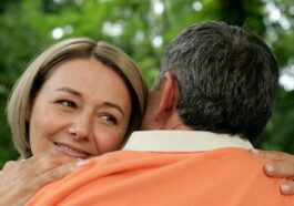 Close-up of a mature couple sharing a loving embrace in a serene outdoor setting.
