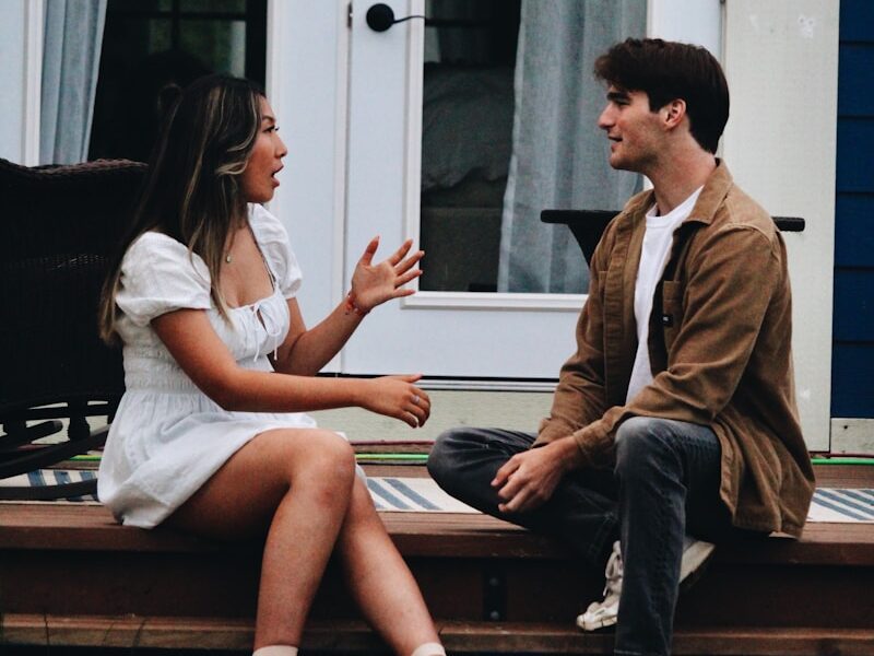 a man and woman sitting on a porch