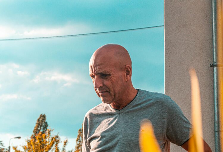 Portrait of a senior man enjoying a sunny day outdoors in Belgium.