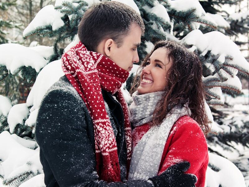 Couple enjoying a loving embrace in a snowy forest, exuding warmth and happiness.