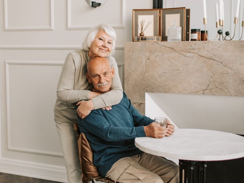 Elderly couple enjoying a warm moment together in their cozy home setting.