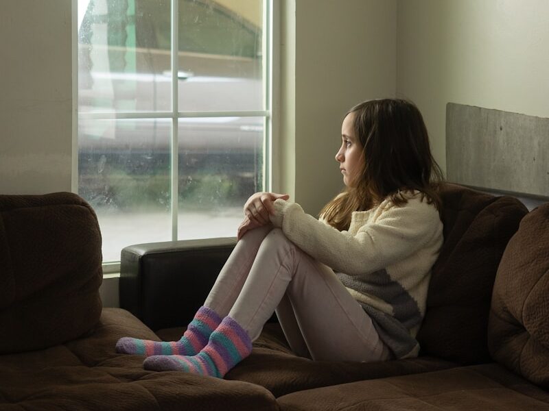 woman in white long sleeve shirt sitting on black couch