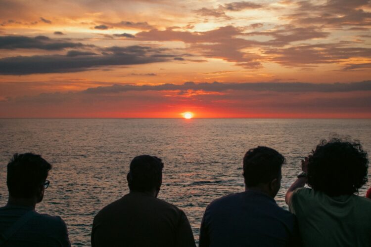 People watch the sunset over the ocean.