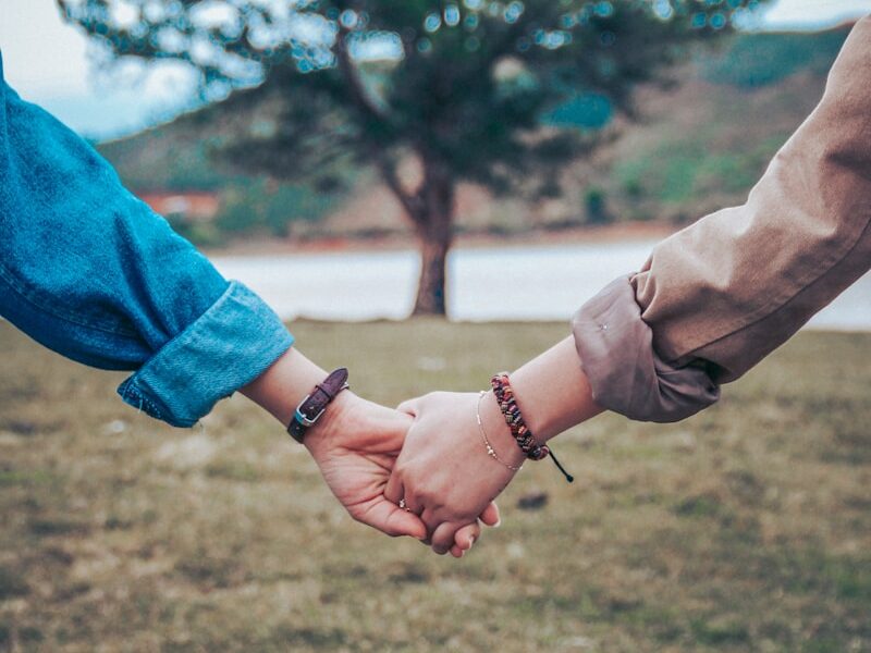 two persons holding hands