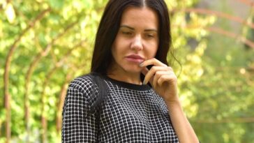 A woman in black and white shirt standing on a path