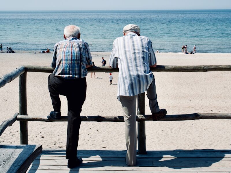 man and woman standing on beach during daytime