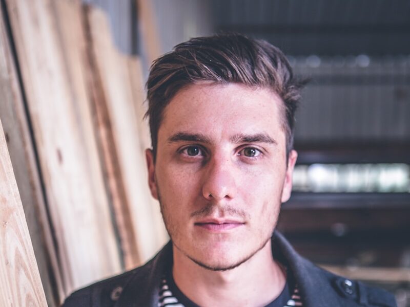 man standing beside wood planks