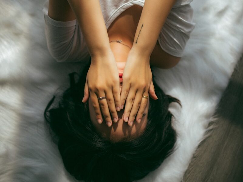 a woman holds her hands over her face