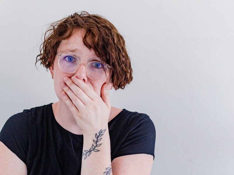 a woman covers her mouth with her hands
