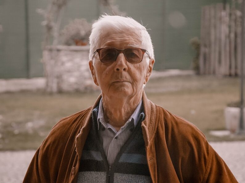 man in brown jacket wearing black framed eyeglasses