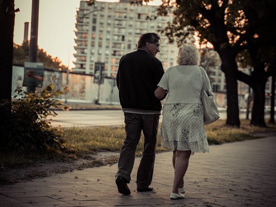 couple walking on sidewalk during daytime