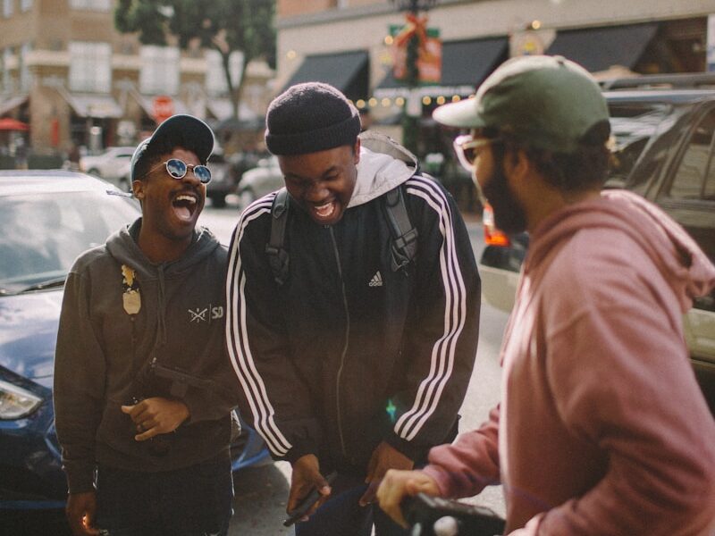 three men in jacket laughing at each other