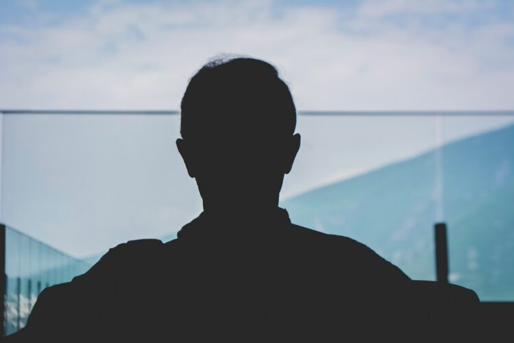 man in black shirt standing near body of water during daytime