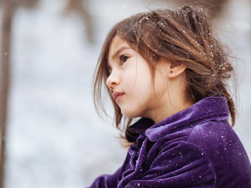 girl wearing purple jacket across blurry background