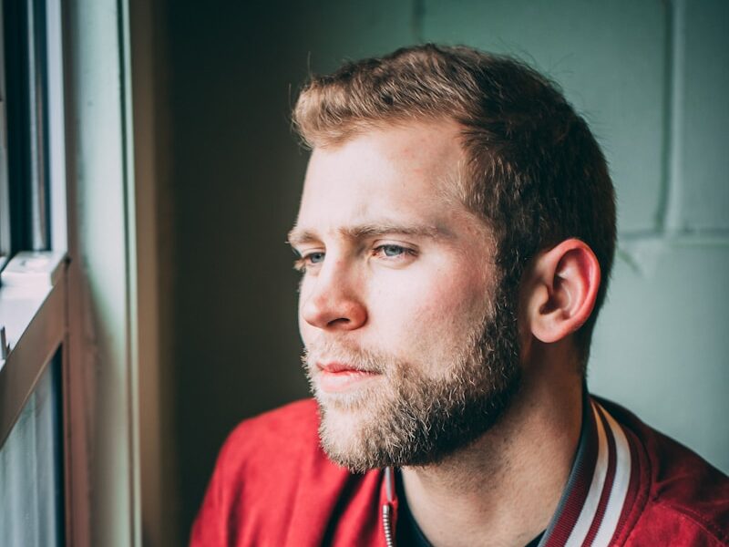man in red and black zip up jacket