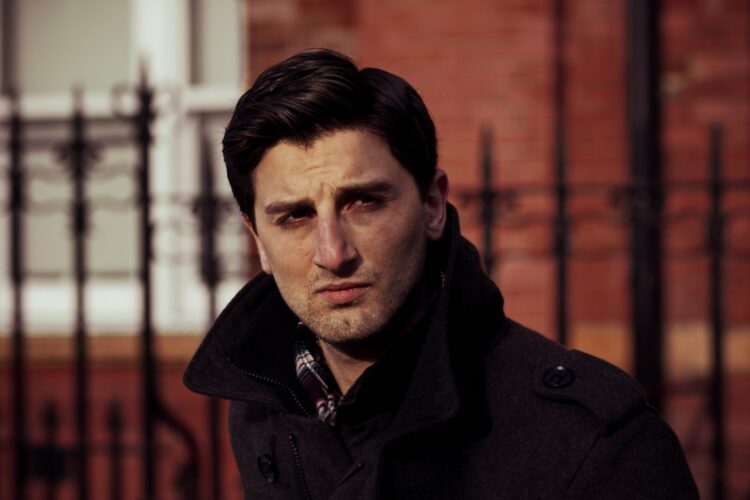 a man standing in front of a fence