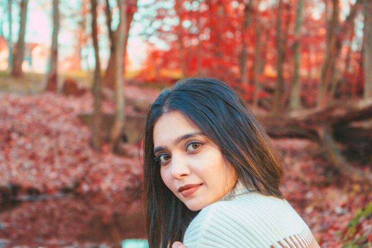 a woman in a white sweater is posing for a picture