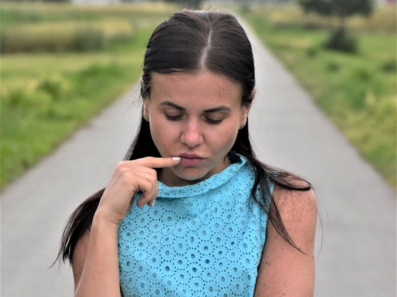 a woman in a blue dress holding a cigarette