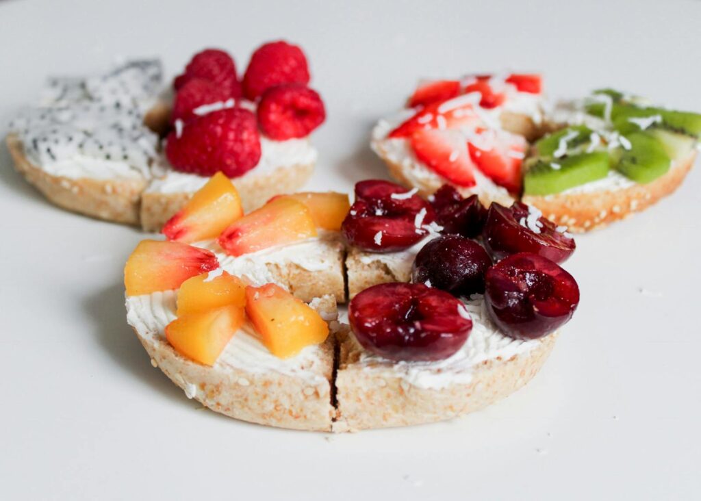 Fruit topped bagels with cream cheese, perfect for a healthy breakfast or brunch.