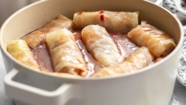 Appetizing stuffed cabbage rolls simmering in a pot with a rich sauce.