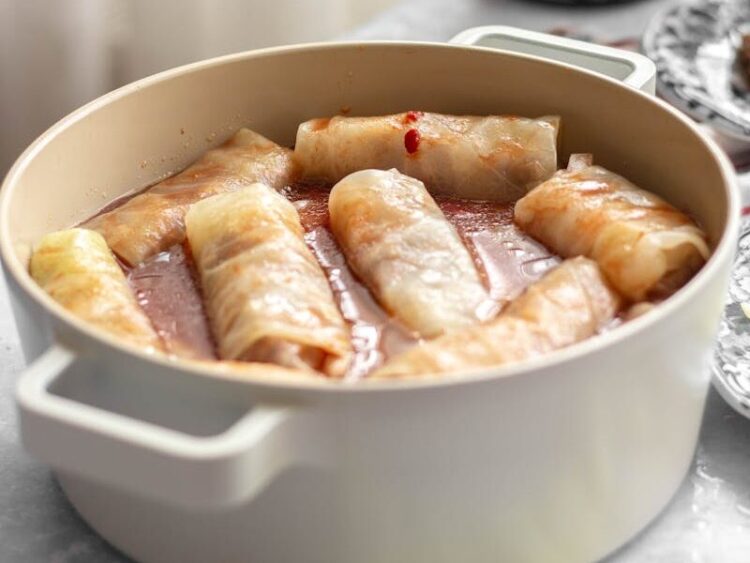 Appetizing stuffed cabbage rolls simmering in a pot with a rich sauce.