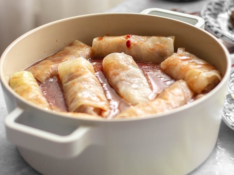 Appetizing stuffed cabbage rolls simmering in a pot with a rich sauce.