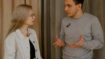 A young couple passionately discussing indoors, capturing intense emotions and gestures.