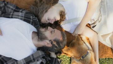 A loving couple enjoying a peaceful moment outdoors with their dog.