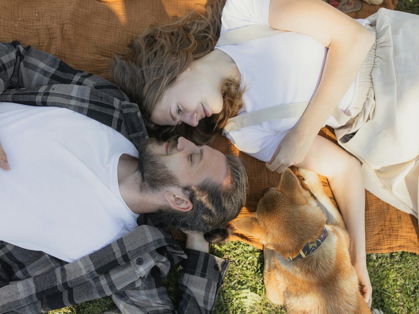 A loving couple enjoying a peaceful moment outdoors with their dog.