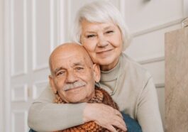 Elderly couple enjoying a warm and loving moment indoors, drinking together.