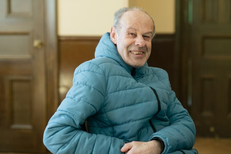 a man in a blue jacket is sitting down