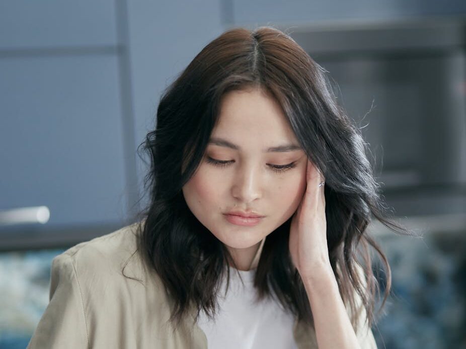 Young woman reviewing paperwork at home, focused and concerned.