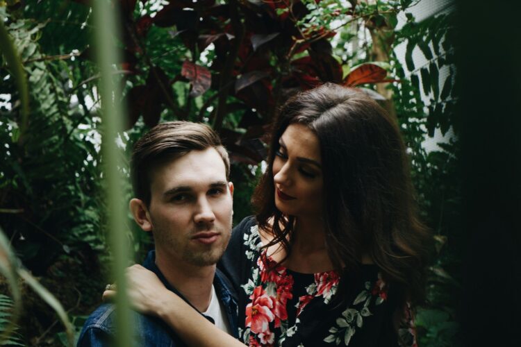 man in blue top carrying woman in floral top