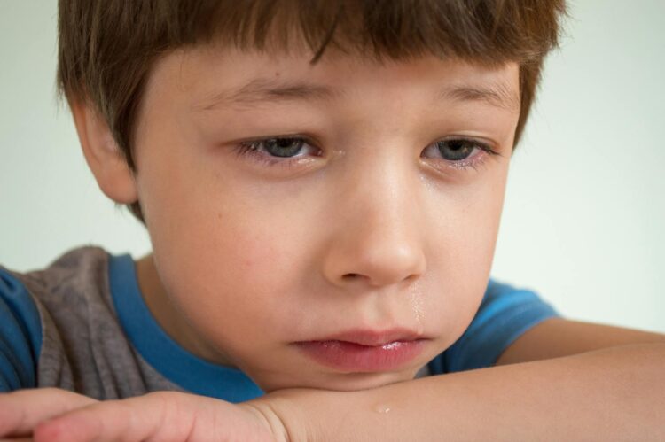 Close-up of a young boy looking sad and emotional, capturing deep feelings.