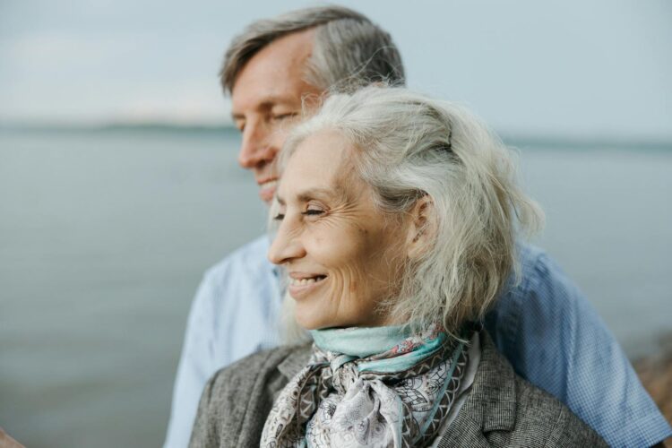 Senior couple sharing a romantic moment by the lake, showcasing love and togetherness.