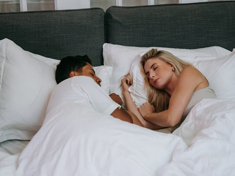 A relaxed couple sleeping together in a cozy bedroom, expressing love and tranquility.