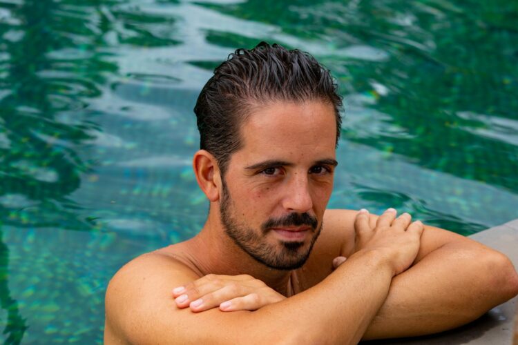 A man with his arms crossed sitting in a pool