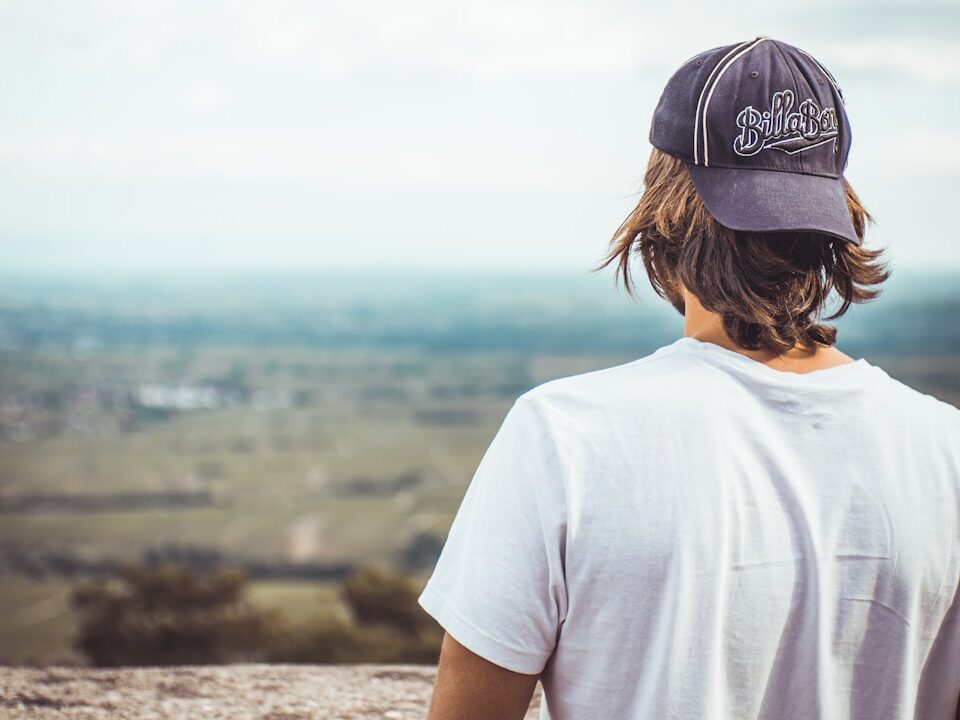 man in white crew neck t-shirt wearing black cap