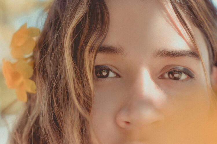 a close up of a person with flowers in her hair