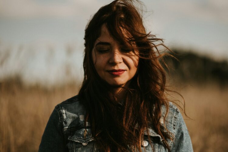 selective focus photography of smiling woman surrounded by wheat field