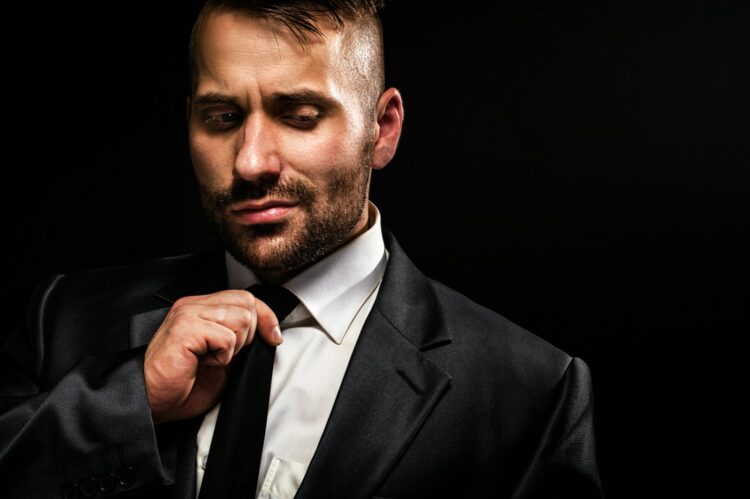 a man in a suit adjusting his tie