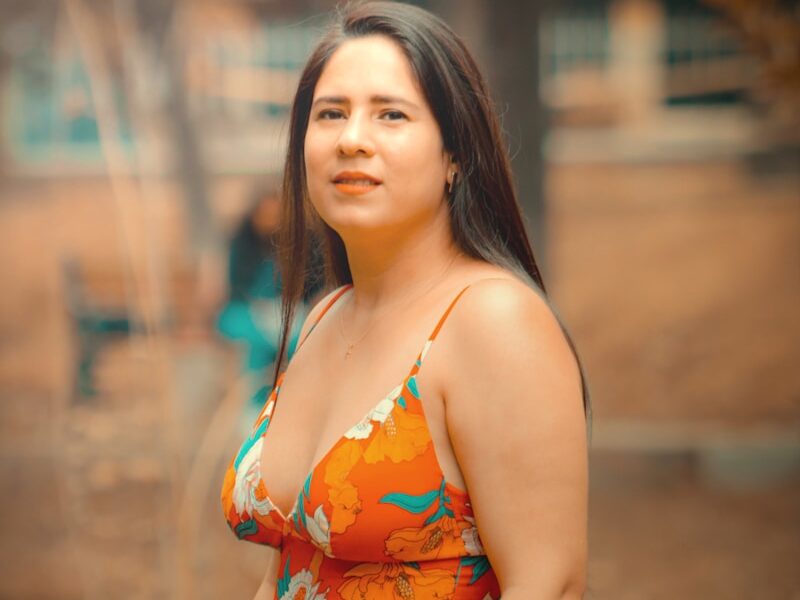a woman in a floral top poses for a picture