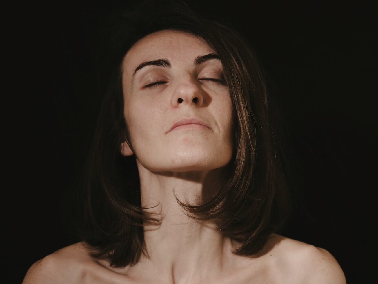 a woman with her eyes closed in the dark