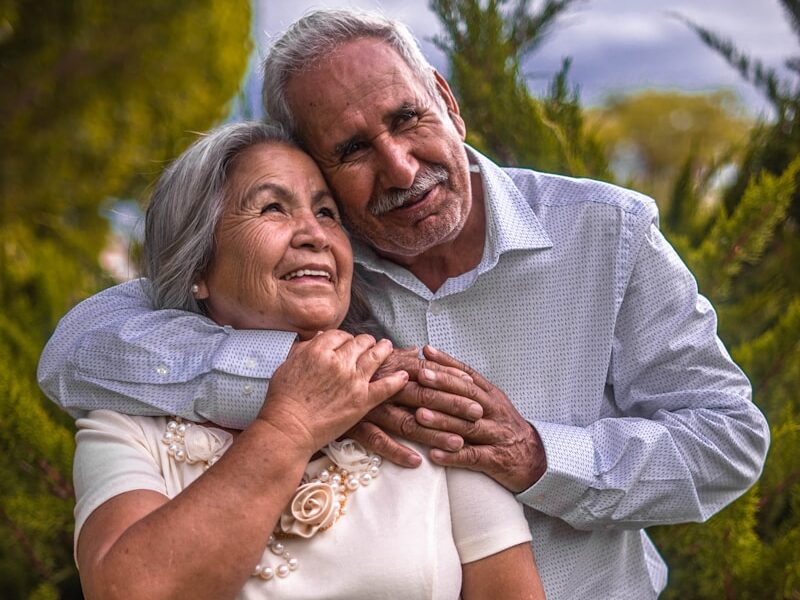 man in white dress shirt hugging woman in white dress